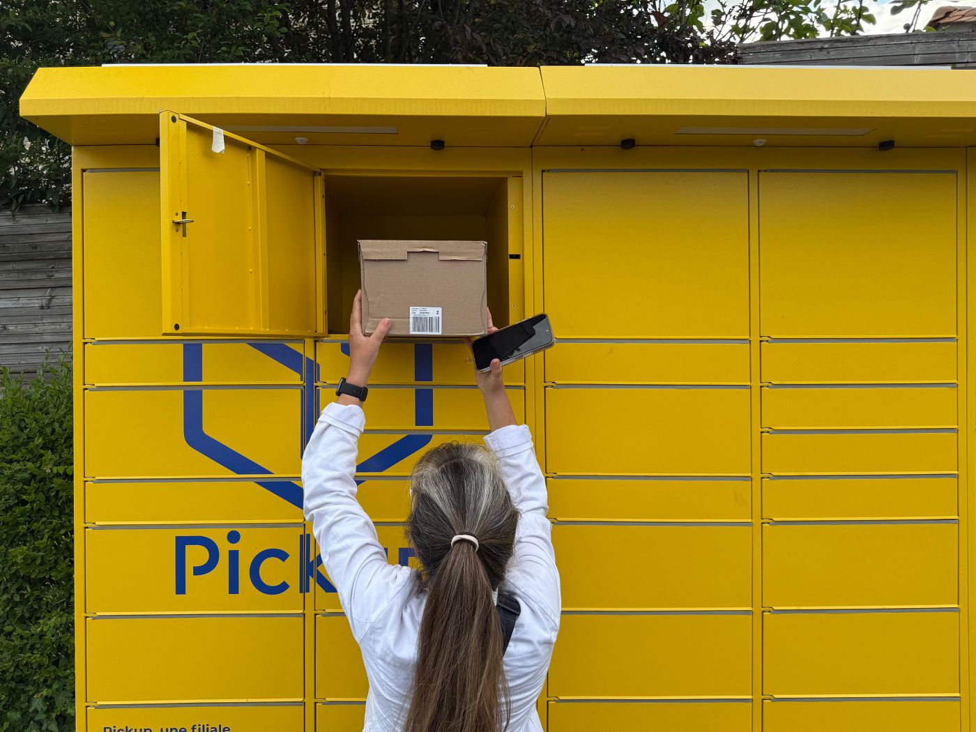 Mujer recogiendo un paquete en una taquilla automática
